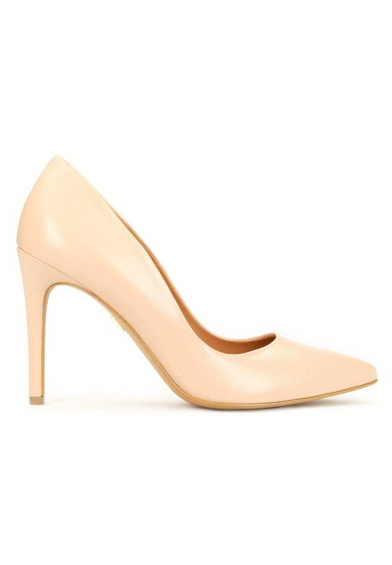 Nude usnjena visoka petka s pointy prstom, gladko teksturo in vitko 10-centimetrsko peto. Ima rahlo ukrivljen izrez spredaj.