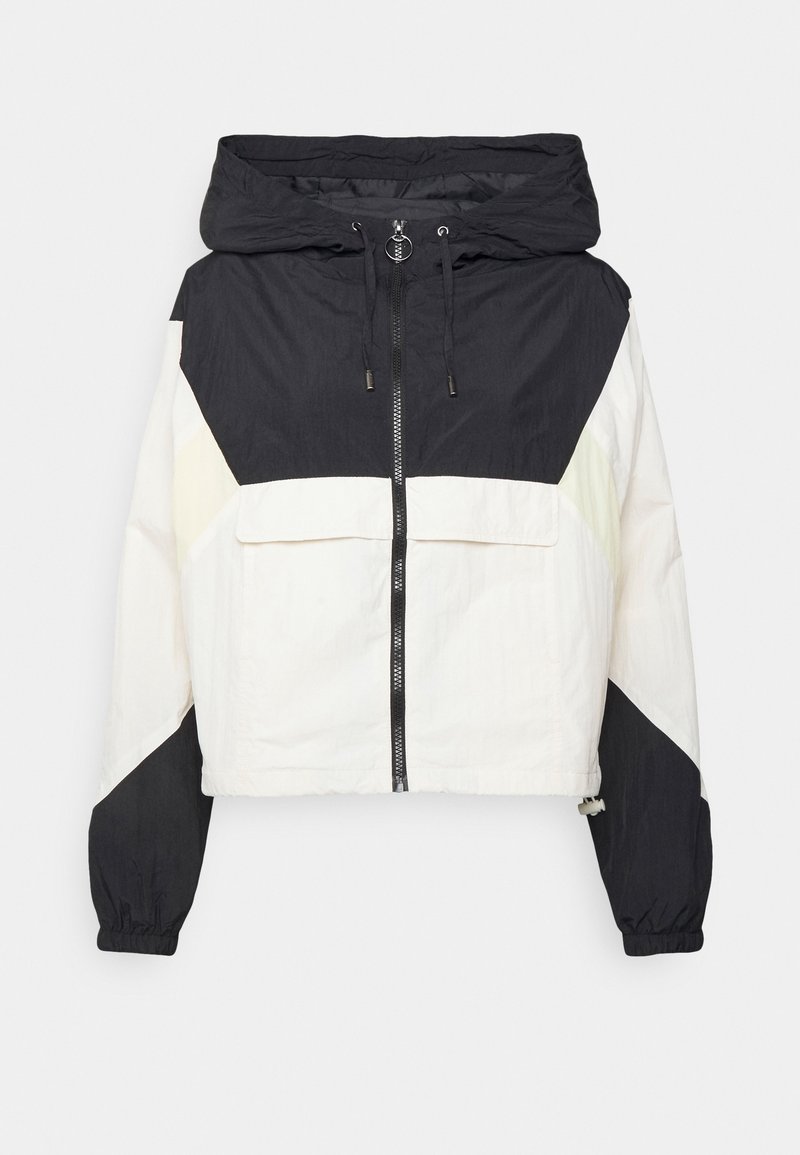 Veste coupe-vent à capuche noire et blanche avec fermeture éclair frontale, capuche à cordon, anneau de tirage de la fermeture éclair, poignets élastiques et grande patte de poche frontale.