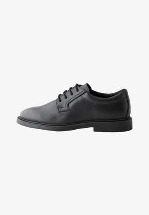 Chaussure de ville pour homme en cuir noir avec fermeture à lacets à cinq œillets et talon bas, vue de profil sur fond blanc.