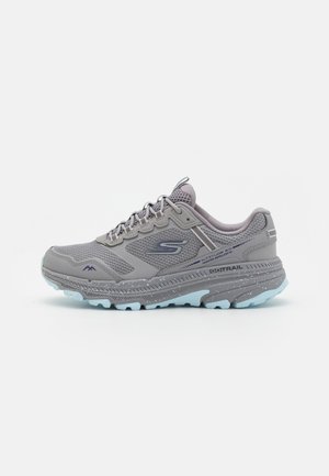 Gray athletic shoe with mesh upper, padded collar, and reflective accents. Features cushioned sole and light blue tread for traction.
