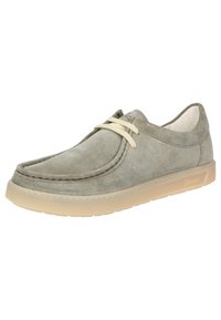 Chaussure en suede gris avec un bout rond, tige en cuir nubuck, lacets crème et une semelle en caoutchouc translucide avec des accents striés.