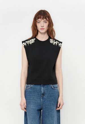 Black sleeveless top with shoulder embellishments, featuring a rounded neckline and a fitted waist. Made from a soft, smooth fabric.