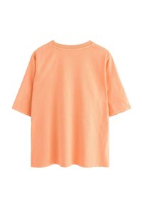 Kortærmet t-shirt med rund hals lavet af bomuld i blød koralfarve. Har en afslappet pasform og et enkelt design med minimale syninger.