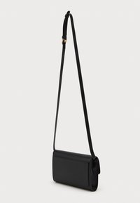 Fekete téglalap alakú keresztpántos táska, vékony állítható pánttal és kis arany csattal, sima fehér háttér előtt.