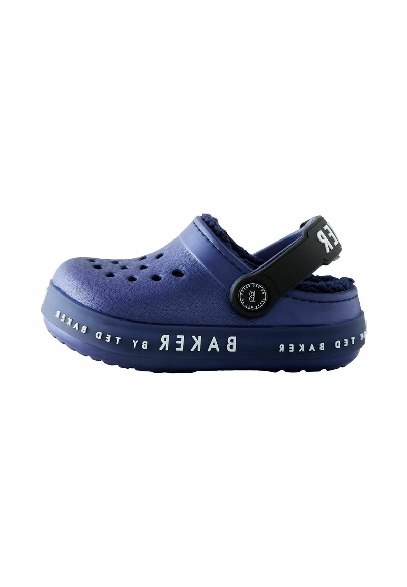 Ljubičasti klompi s ventilacijskim otvorima, mekanom podstavom i crnim remenom. "BAKER" logo u bijeloj boji duž bočne strane. Teksturirana potplata za prianjanje.