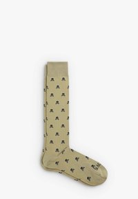 Calze beige con un motivo ripetuto di teschi e ossa incrociate nere, dotate di un polsino a coste e una punta rinforzata per una maggiore durata.