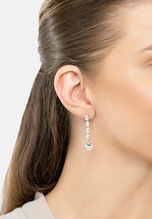 Long silver-tone earrings featuring multiple clear teardrop and round rhinestones arranged in a cascading design, elegant and reflective.