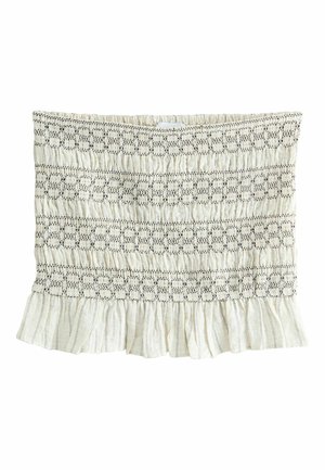 Haut tube en tissu blanc avec texture smockée, motifs de couture horizontale noire et ourlet à volants en bas.