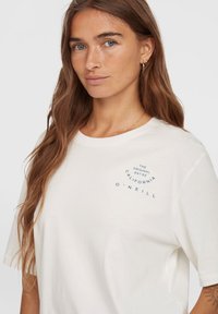 Weißes Baumwoll-T-Shirt mit rundem Ausschnitt, mit blauem grafischem Textdesign auf der Vorderseite. Kurze Ärmel und lässige Passform.