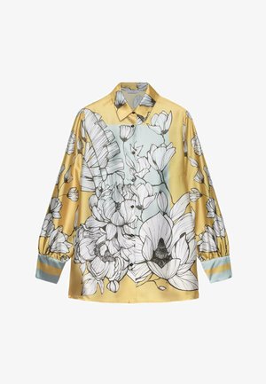 Satinbluse mit einem gelb-blauen Colorblock-Design und großen Blumenillustrationen in Schwarz und Weiß. Vorderseite mit Knopfleiste und gepufften Ärmeln.