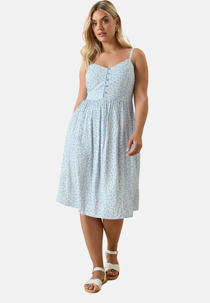 Blå och vit mönstrad klänning med tunna axelband, knappframsida, figursydd bodice och en utsvängd, knälång kjol; bomullstyg med fickor.