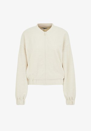 Krátka bomber bunda v krémovej farbe. Textúrovaná látka so zipsom vpredu, rebrovanými manžetami a okrúhlym golierom. Vyzdobená detailom na stiahnutom páse.