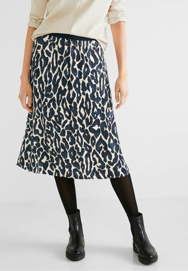 Leopardmönstrad kjol i marinblått och krämfärgat, midjehöjd, slätt tyg med elastisk midja. I kombination med svarta ankelstövlar.