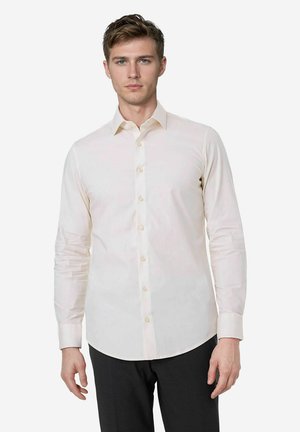 Hellbeige Langarmshirt mit spitzem Kragen, Knopfverschluss vorne und glatter Textur. Der Stoff ist leicht tailliert und hat geknöpfte Manschetten.