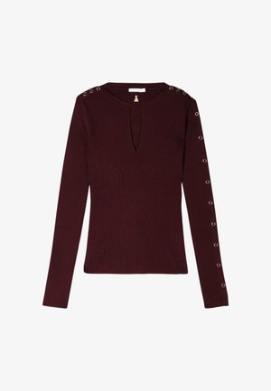 Top lungo bordeaux a maniche lunghe con scollatura a chiave, texture a coste e occhielli metallici decorativi lungo le maniche.