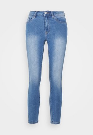 Calças skinny de ganga azul claro. Apresentam um design de cinco bolsos, fecho com botão e um leve desvanecimento nas coxas.