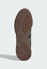 Zwart en grijs sneaker zool met een getextureerd rubberen oppervlak, voorzien van golvende groeven en "Predator" branding.