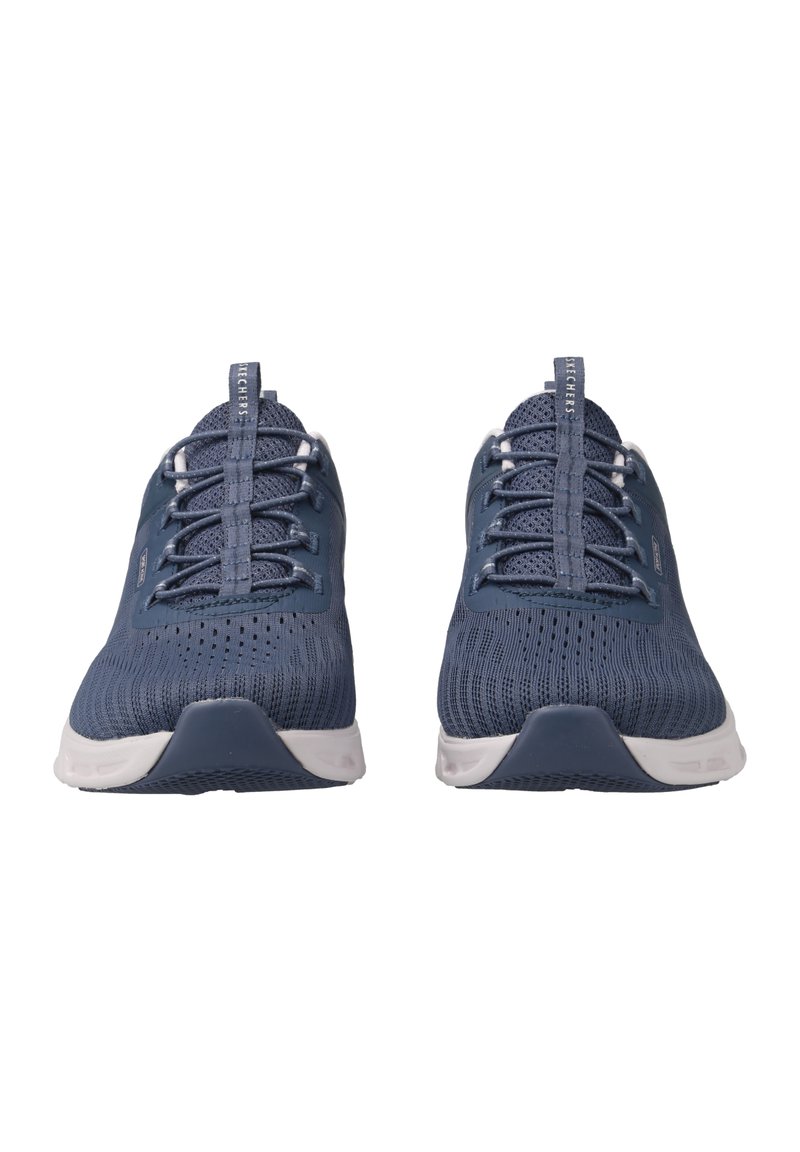 Zapatillas deportivas azules con parte superior de malla, que presentan una superficie texturizada, cordones blancos y una suela de tracción blanca. Diseño de puntera y talón redondeados.