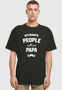 Camiseta de algodón negra con texto blanco que dice "MIS PERSONAS FAVORITAS me llaman PAPA," con un gráfico de un bigote debajo del texto.