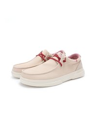 Zapatillas de lona beige con acentos rojos, que cuentan con una puntera redondeada, suela blanca ligera y un diseño de forro interior a rayas.