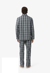 Set di pigiama a quadri blu e verdi realizzato in tessuto morbido, composto da una giacca con bottoni, maniche lunghe e pantaloni abbinati con elastico in vita.