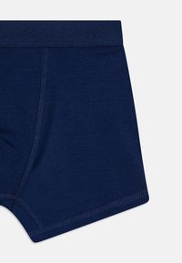 Marineblå bomullsboxershorts med myk elastisk linning og flate sømmer, med en jevn tekstur og minimalistisk design.