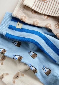 Patru perechi de șosete cu modele în tonuri bej și albastre, cu dungi, croissante zâmbitoare, covrigi și cartonase de lapte.