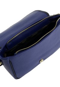 Blauwe leren tas met een gestructureerd oppervlak, voorzien van een gouden rits en een drukknoopsluiting. Het interieur heeft een zwarte voering en details van zakken.