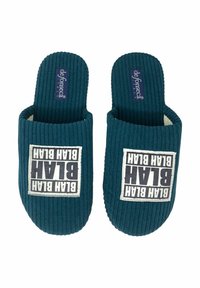 Pantofole in tessuto a coste turchese con una toppa bianca che riporta la scritta "BLATH BLATH" in caratteri neri e in grassetto. Fodera interna morbida e design aperto.