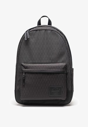 Sac à dos noir à motif losange avec poche avant zippée et poignée supérieure, avec un patch de marque rectangulaire sur la poche avant inférieure.