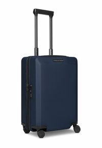 Valise rigide bleu marine avec une finition texturée, poignée noire rétractable et quatre roues pivotantes à 360 degrés. Équipée d'une serrure à combinaison à glissière.