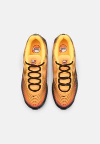 Pair of bright orange and black Nike Air Max sneakers with black laces, dotted pattern design, and visible Air Max logo inside.