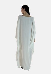 Lang hvid kaftan med brede ærmer, lavet af letvægtsstof, med en afslappet pasform og glat tekstur.