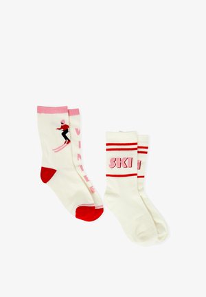 Two pairs of crew socks. One pair has a skier graphic, pink accents, and "WINTER" text; the other has red stripes and "SKI" text.