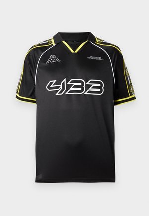 Black sports jersey with a collar, featuring yellow accents, white graphics, and short sleeves. Material appears lightweight and smooth.