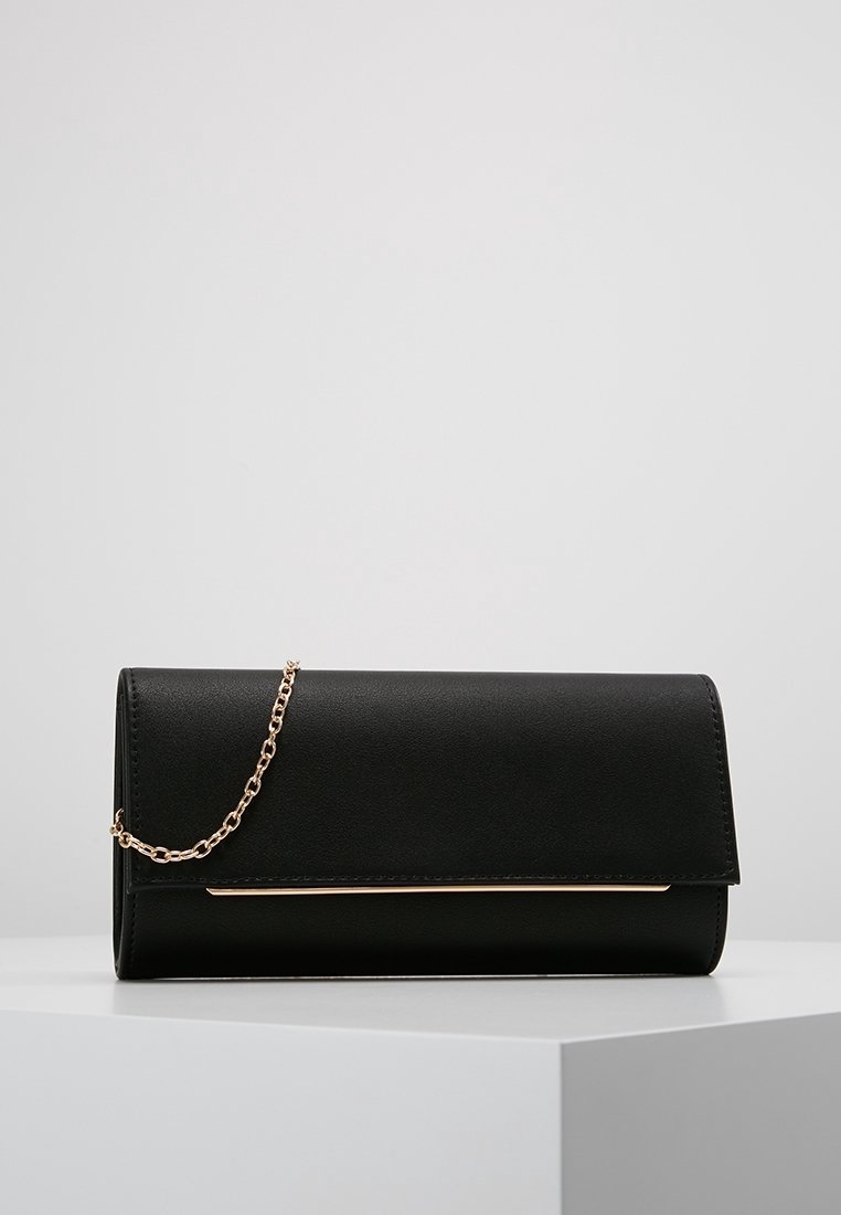 Bolso de mano negro de imitación cuero con cierre de solapa, que presenta una correa de cadena dorada y un elegante detalle dorado en la parte frontal.