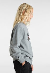 Grå sweatshirt med en grafisk design på framsidan, med ribbade muddar och nederkant. Tyget ser mjukt ut och har en avslappnad passform.