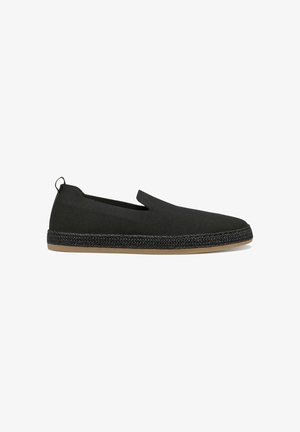 Chaussures noires à enfiler en tissu texturé avec une semelle semblable à du jute tissée. Comprend des panneaux latéraux élastiques et une petite languette à l'arrière.