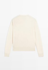 Maglione chiaro di crema con maniche lunghe, colletto e polsini a coste, e una texture morbida. Design semplice, senza motivi o dettagli.