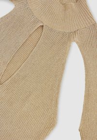 Metalinės auksinės juostelės megztinis su aukštu golfo iškirpimu ir išpjovomis pečių srityje, pagamintas iš tekstūruoto mezginio audinio.