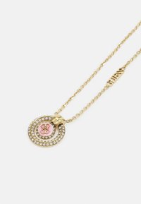 Gouden halsketting met een ronde hanger met roze center en decoratieve rhinestones, verbonden door een delicate ketting.
