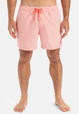 Shorts de bain rayés pêche avec une taille élastique et un cordon de serrage orange néon. Présente un petit logo rouge cousu sur la jambe gauche.