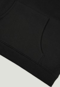 Svarte joggebukser har en sidelomme, ribbet nederkant og glatt bomullsblandingsstoff. Enkel design med fokus på funksjonalitet.