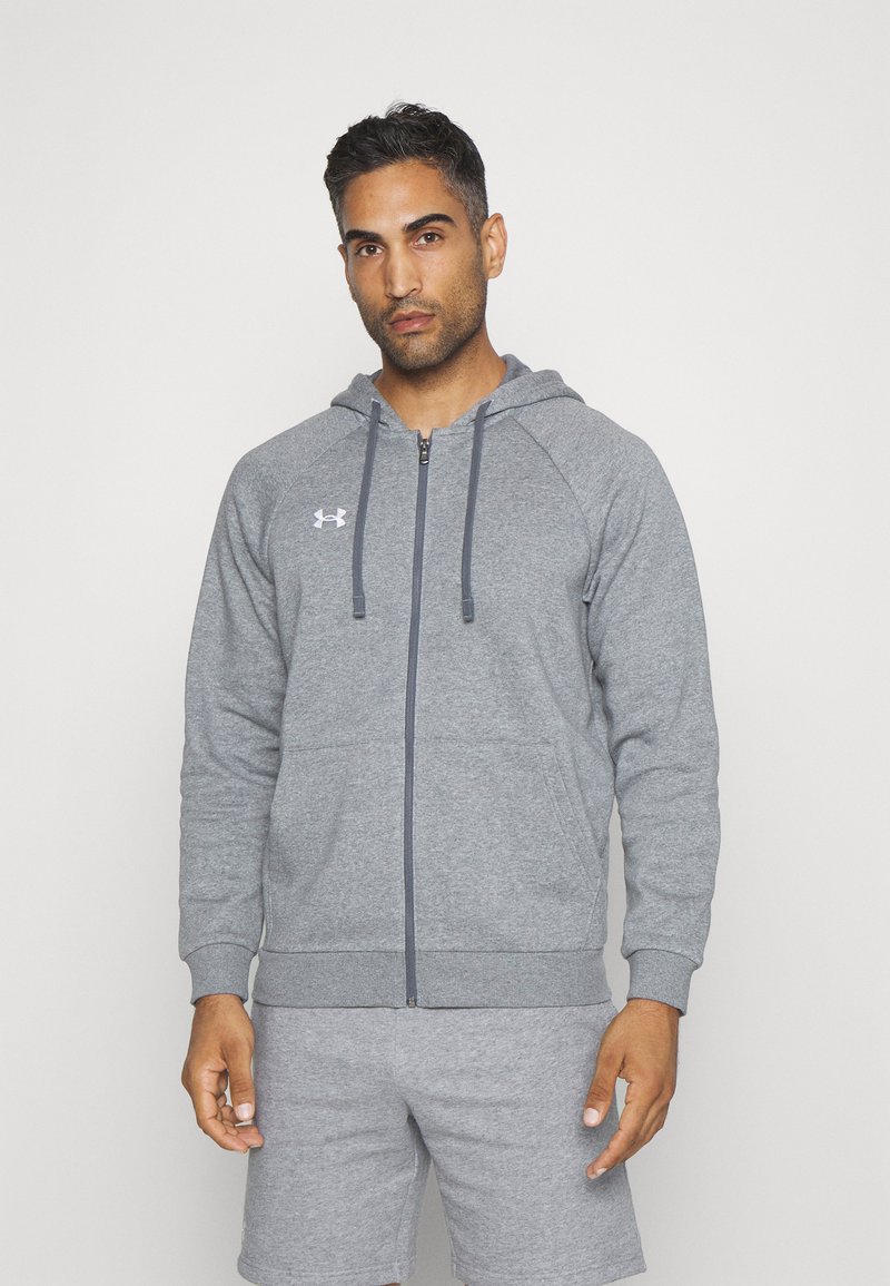 Grå zip-up hettegenser laget av mykt materiale, med en front glidelås, ribbet mansjetter og hette. Under Armour-logoen er vist på brystet.