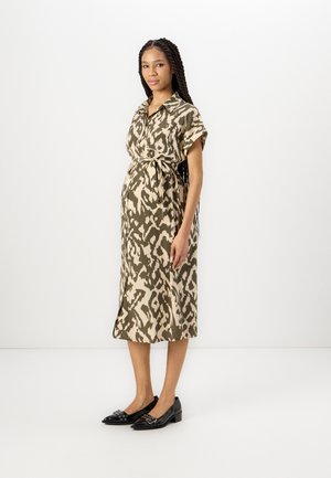 Lyhythihainen, polvipituinen mekko vihreässä ja beige eläinkuosissa, jossa on itse solmittava vyö vyötäröllä. Yhdistetty mustiin, matalakorkoisiin kenkiin.
