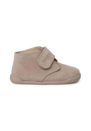 Beige suède peuteranklaarshoes met een ronde neus, klittenbandsluiting en een getextureerde rubberen zool voor grip; eenvoudig en functioneel ontwerp.