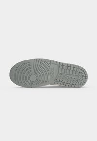 Γκρι σόλα παπουτσιού Nike με κυκλικά και ορθογώνια σχέδια πέλματος και το λογότυπο της Nike στο κέντρο.
