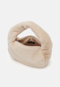Sac à main en fausse fourrure beige avec une poignée arrondie et moelleuse, et fermeture éclair, doté d'une doublure intérieure lisse. Compact et texture douce.
