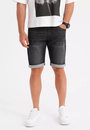 Shorts en denim gris foncé, avec un ourlet roulé, un design à cinq poches et une coupe slim, accompagnés d'un t-shirt graphique à manches courtes.