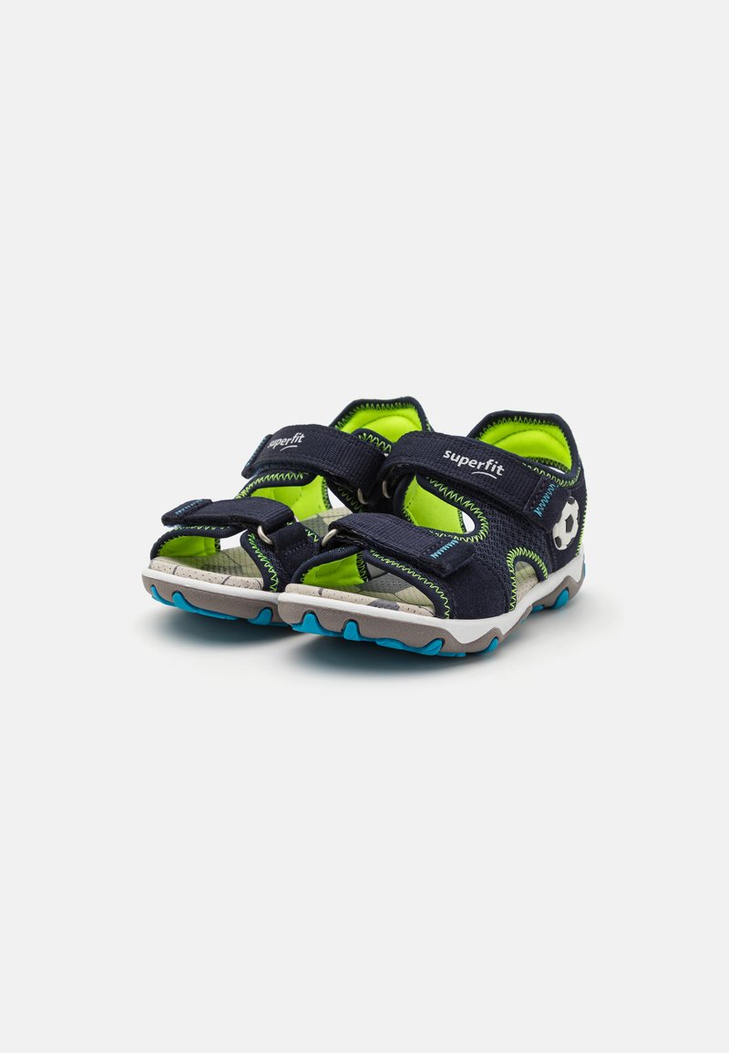 Marineblaue Sandalen mit grünen Akzenten, verstellbaren Klettverschlüssen, offenem Zehendesign und strukturierten Gummisohlen für Halt und Unterstützung.